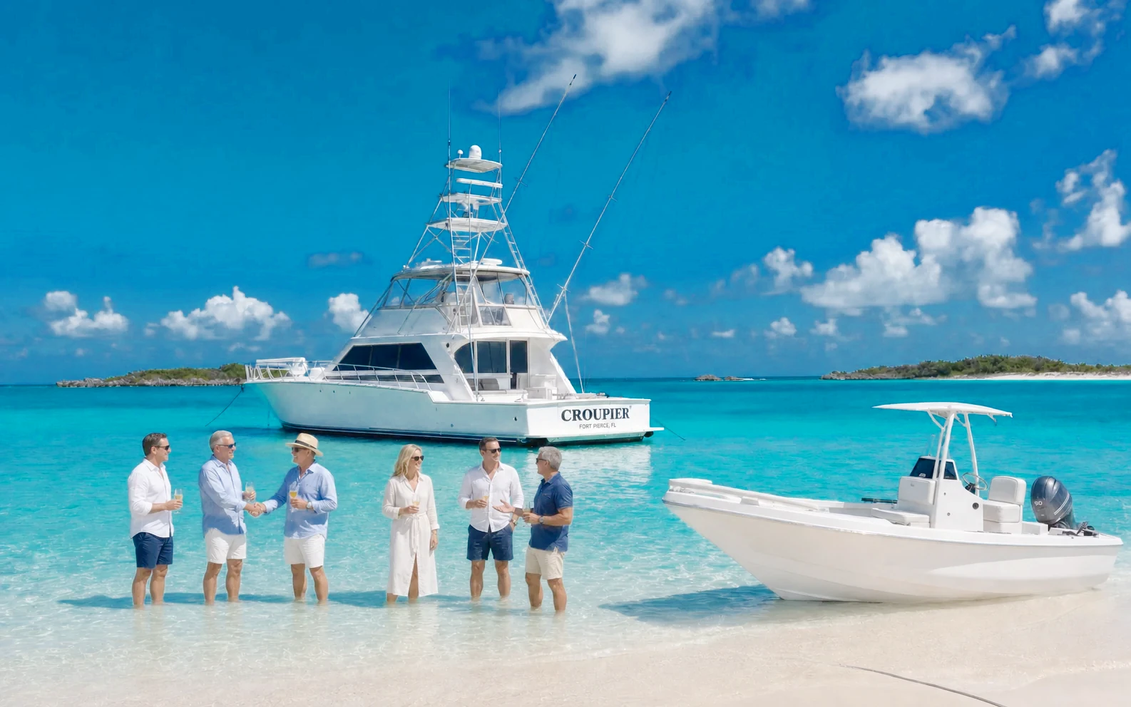 CROUPIER anchored off a Bahamian sandbar with guests in the shallows